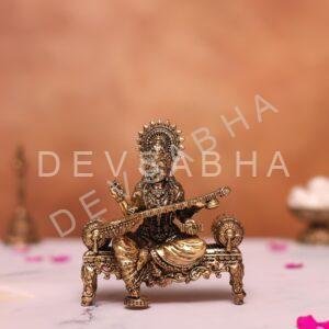brass saraswati statue sitting on sofa