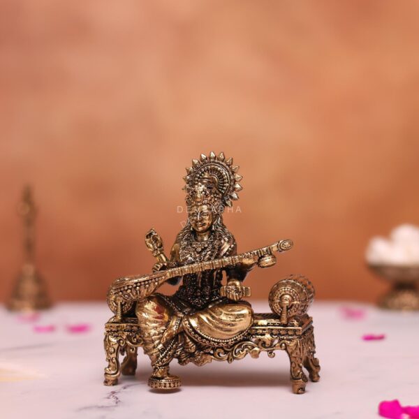Brass saraswati statue sitting on sofa