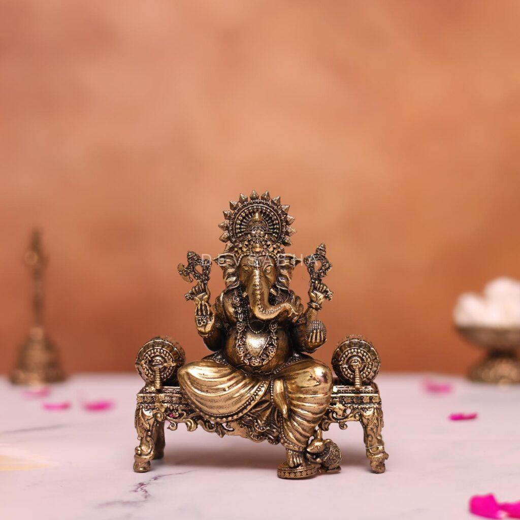 brass ganesh statue sitting on sofa