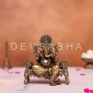 brass ganesh statue sitting on sofa