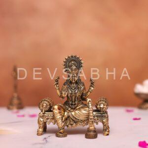 brass laxmi statue sitting on sofa