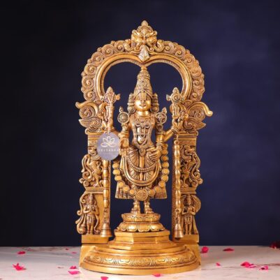 Front view of large brass balaji with intricate carvings and ornate arch design
