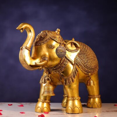 Front view of ornate brass elephant with raised trunk and decorative bells