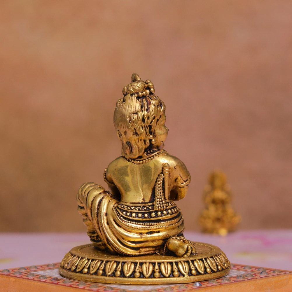 a gold statue of a child krishna