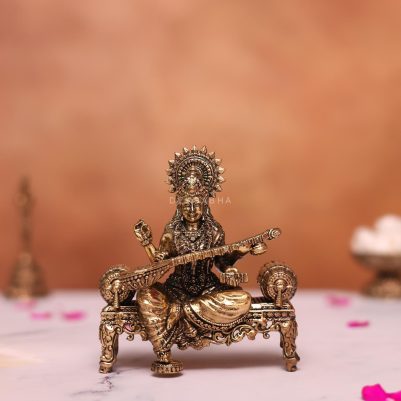 brass saraswati statue sitting on sofa