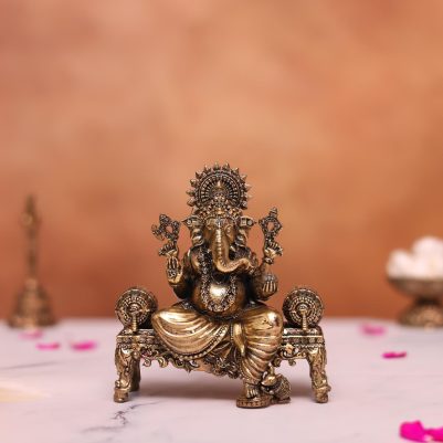 brass ganesh statue sitting on sofa