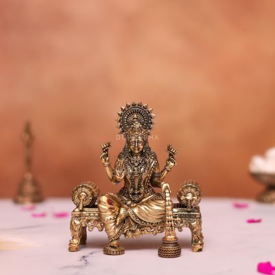 brass laxmi statue sitting on sofa