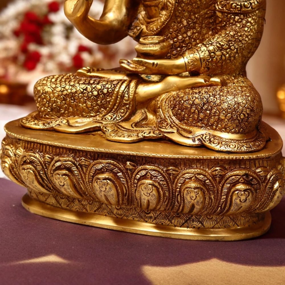 a brass statue of a person sitting on a table